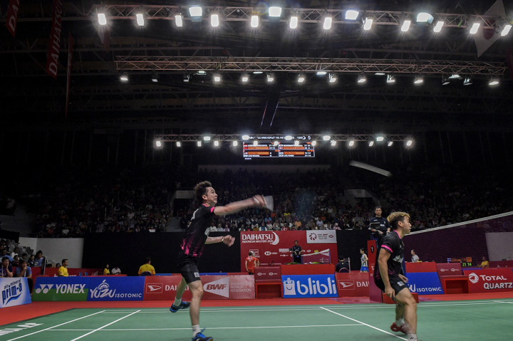 Pebulu tangkis ganda putra Indonesia Kevin Sanjaya Sukamuljo (kiri) disaksikan rekannya Marcus Fernaldi Gideon mengembalikan kok ke arah lawannya asal Tiongkok He Ji Ting dan Tan Qiang dalam pertandingan babak 16 besar Daihatsu Indonesia Masters 2020 di Istora Senayan. 