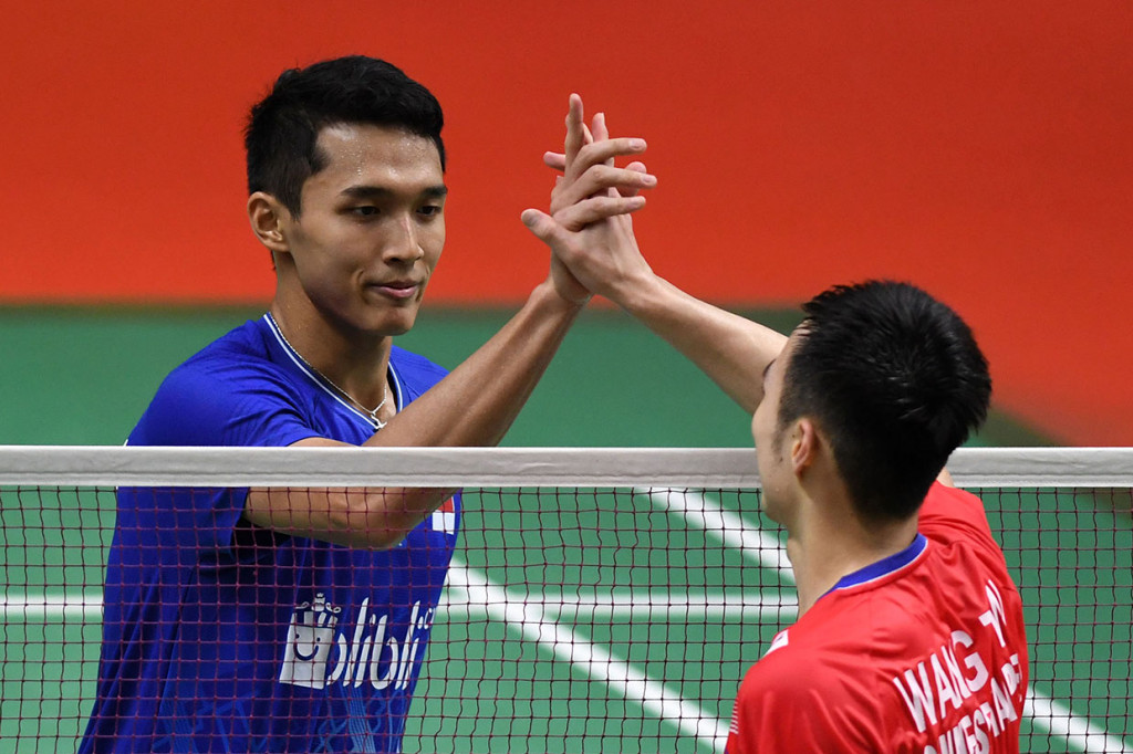 Pebulu tangkis tunggal putra Indonesia Jonatan Christie menjabat tangan lawannya asal Taiwan Wang Tzu Wei usai menang dalam pertandingan babak 16 besar Daihatsu Indonesia Masters 2020 di Istora Senayan, Jakarta.