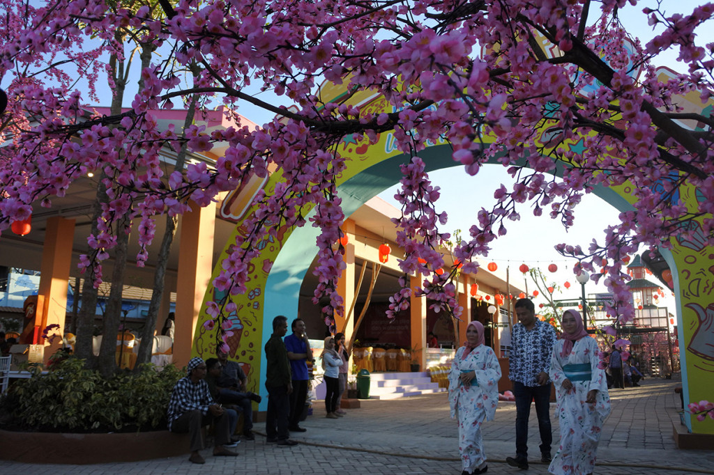 Pengunjung berjalan dengan model berbaju kimono menikmati destinasi wisata di Dira Park Balung, Jember, Jawa Timur, Jumat, 17 Januari 2020. 