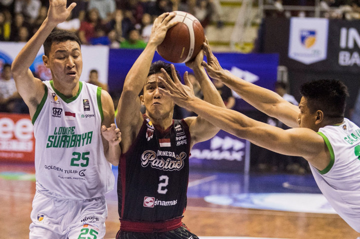 Dua pebasket Louvre Surabaya Galank Gunawan (kanan) dan Dio Tirta Saputra (kiri) berusaha merebut bola dari pebasket Indonesia Patriots Hardianus Lakudu (tengah) saat pertandingan seri kedua IBL Pertamax 2020 di GOR Ctra, Bandung, Jawa Barat.