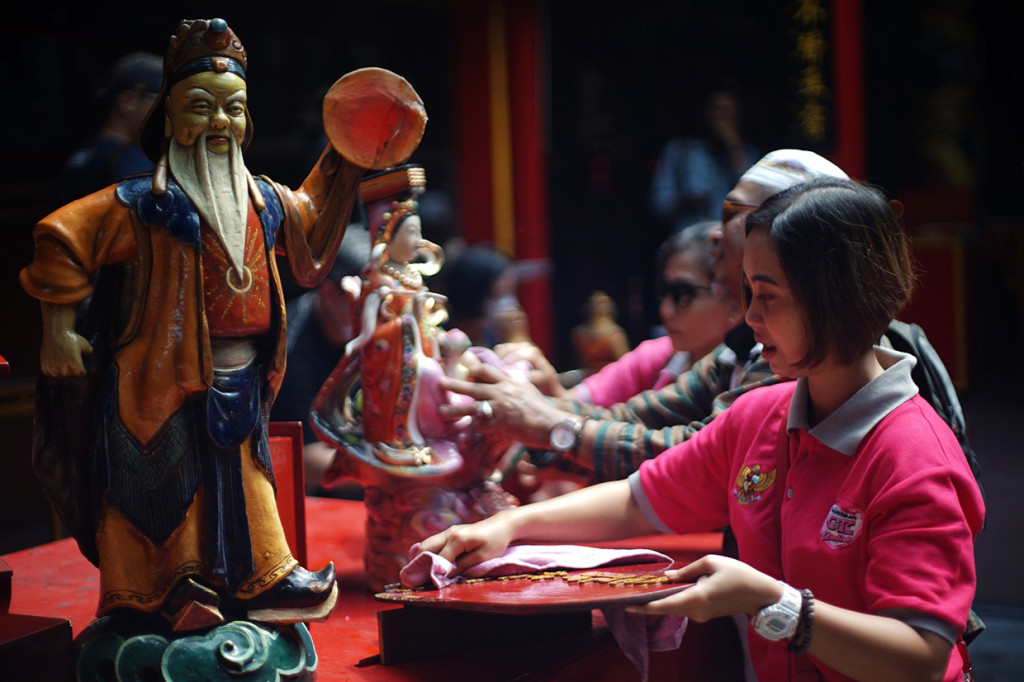 Warga membersihkan patung dewa saat acara bersih klenteng jelang Imlek di Klenteng Fuk Ling Miau, Gondomanan, Yogyakarta. 