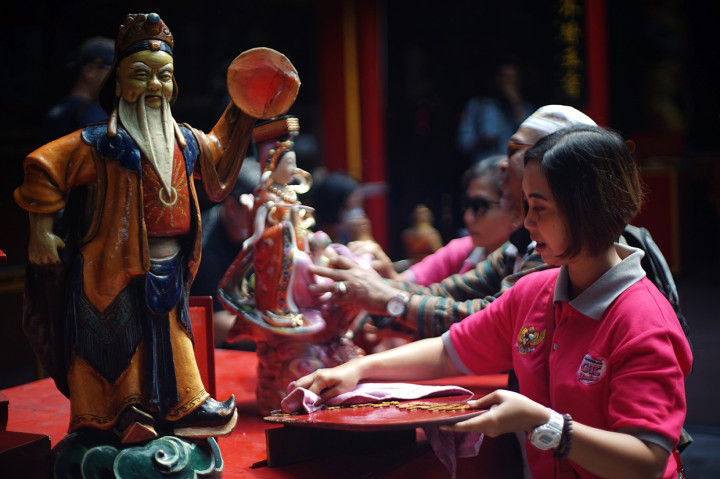 Warga membersihkan patung dewa saat acara bersih klenteng jelang Imlek di Klenteng Fuk Ling Miau, Gondomanan, Yogyakarta. 