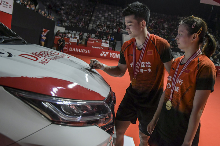 Pebulu tangkis ganda campuran Tiongkok Zheng Si Wei (kanan) dan rekannya Huang Ya Qiong menandatangani kap mobil usai memenangkan pertandingan babak final melawan pebulu tangkis senegaranya Wang Yi Lyu dan Huang Dong Ping di Daihatsu Indonesia Masters 2020 di Istora Senayan, Jakarta.