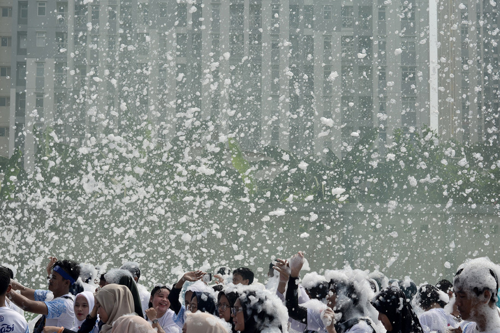 Sejumlah peserta lomba lari santai menikmati siraman busa sabun saat mengikuti kegiatan Indonesia Bubble Run di Bekasi, Jawa Barat.