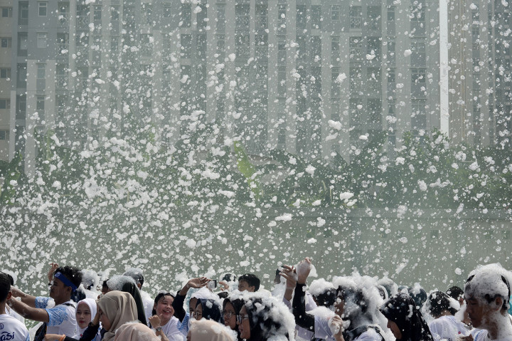 Sejumlah peserta lomba lari santai menikmati siraman busa sabun saat mengikuti kegiatan Indonesia Bubble Run di Bekasi, Jawa Barat.
