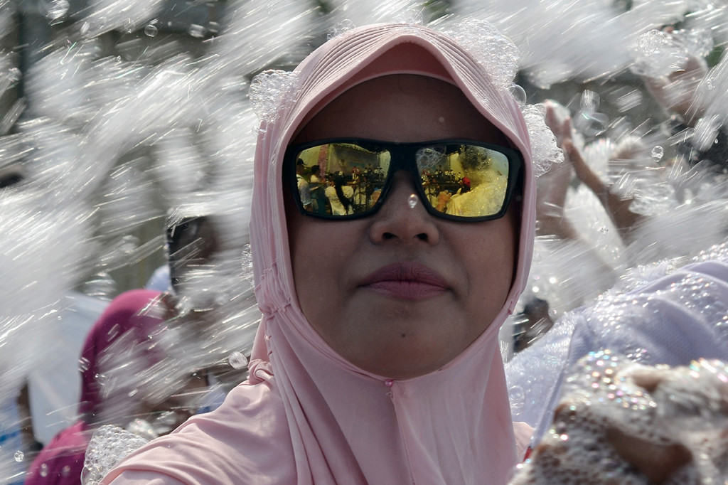 Seorang peserta lomba lari santai menikmati siraman busa sabun saat mengikuti kegiatan Indonesia Bubble Run di Bekasi, Jawa Barat.