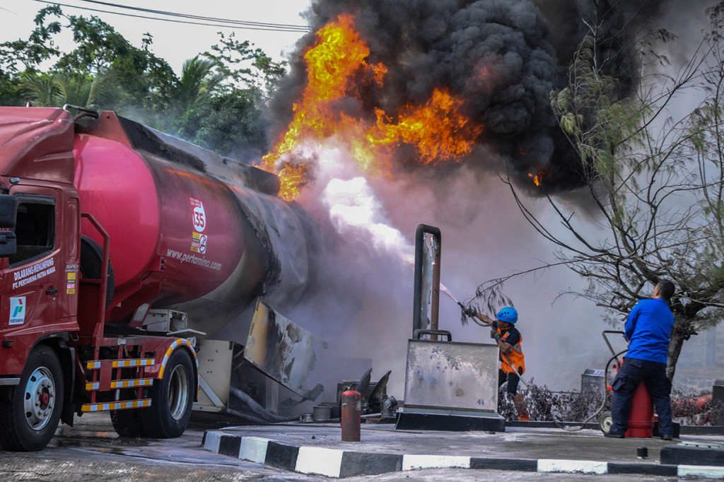 Petugas berusaha memadamkan api pada truk tangki pertamina yang terbakar ketika melakukan pengisian bahan bakar minyak (BBM) di SPBU 3446309 Batulawang, Desa Sukamukti, Kota Banjar, Jawa Barat.

