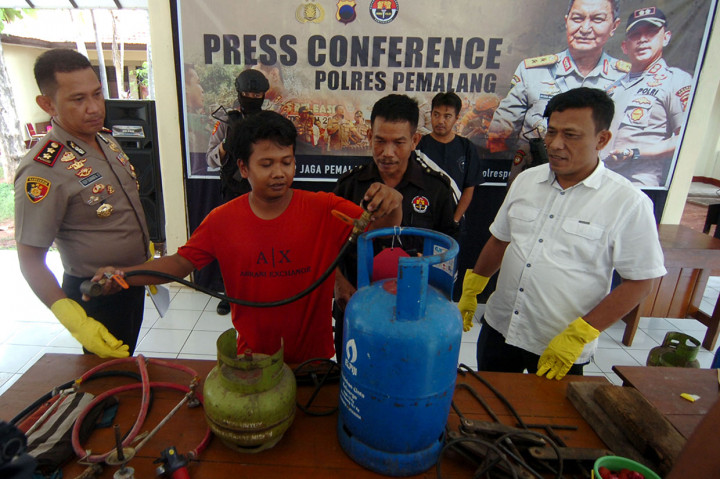 Kapolres Pemalang AKBP Edy Suranta Sitepu (kiri) memperhatikan karyawan pengoplosan mempraktikkan cara mengoplos elpiji subsidi ke non subsidi, saat gelar kasus pengoplosan gas di Polres Pemalang, Jawa Tengah, Selasa, 21 Januari 2020.