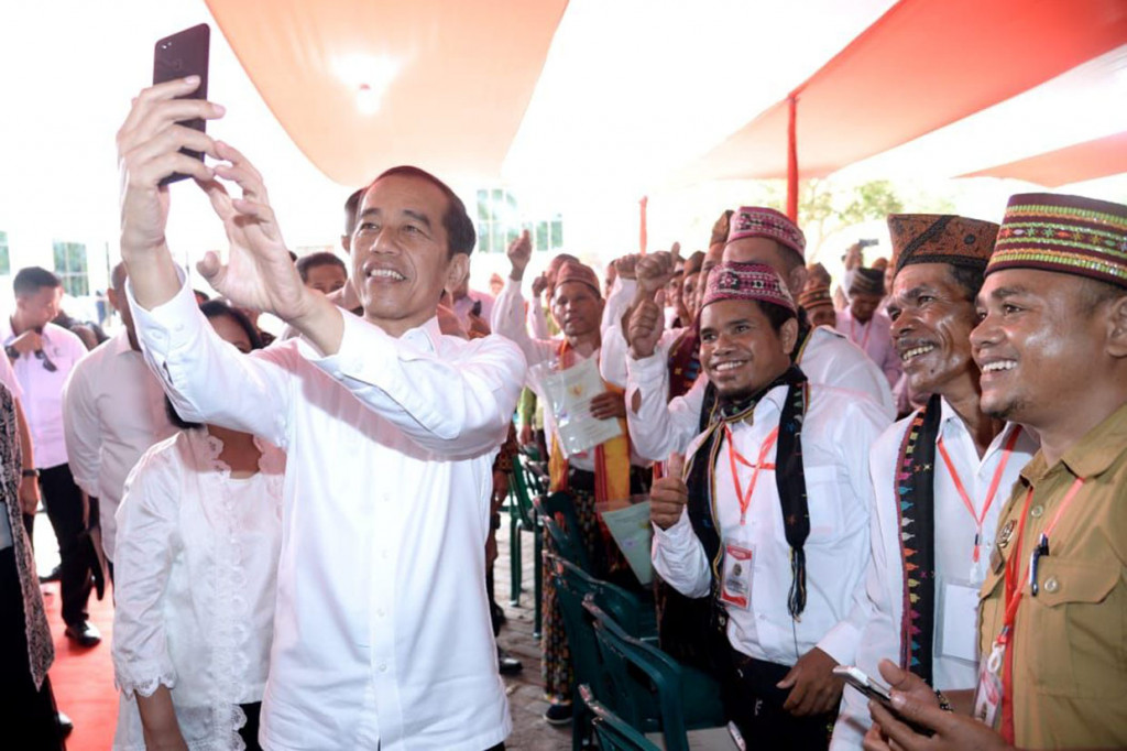 Jokowi melayani permintaan swafoto warga pada acara penyerahan 2.500 sertifikat hak atas tanah untuk rakyat di Kantor Bupati Manggarai Barat, Kecamatan Komodo, Kabupaten Manggarai Barat.