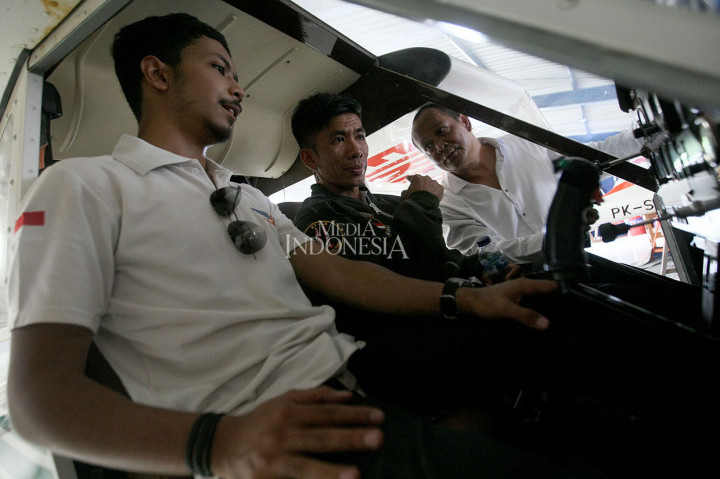 Pembuat pesawat terbang Haerul (tengah) mendapat penjelasan mengenai mesin pesawat dari Wakil Ketua Indonesia Flying Club (IFC) Untung Medianto di Lapangan Terbang Pondok Cabe, Tangerang Selatan.
