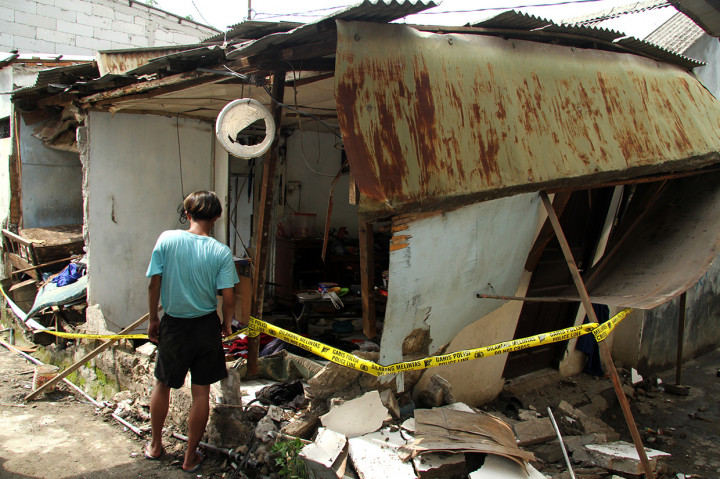 Warga mengamati kondisi rumah dan barang yang hancur yang masih terpasang garis polisi, di kawasan Rawa Bebek, Bekasi, Jawa Barat. 
