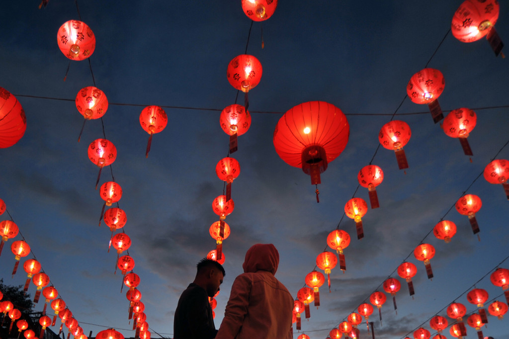 Sejumlah pengunjung menikmati lampion yang dipasang di klenteng See Hin Kiong, Padang, Sumatera Barat.