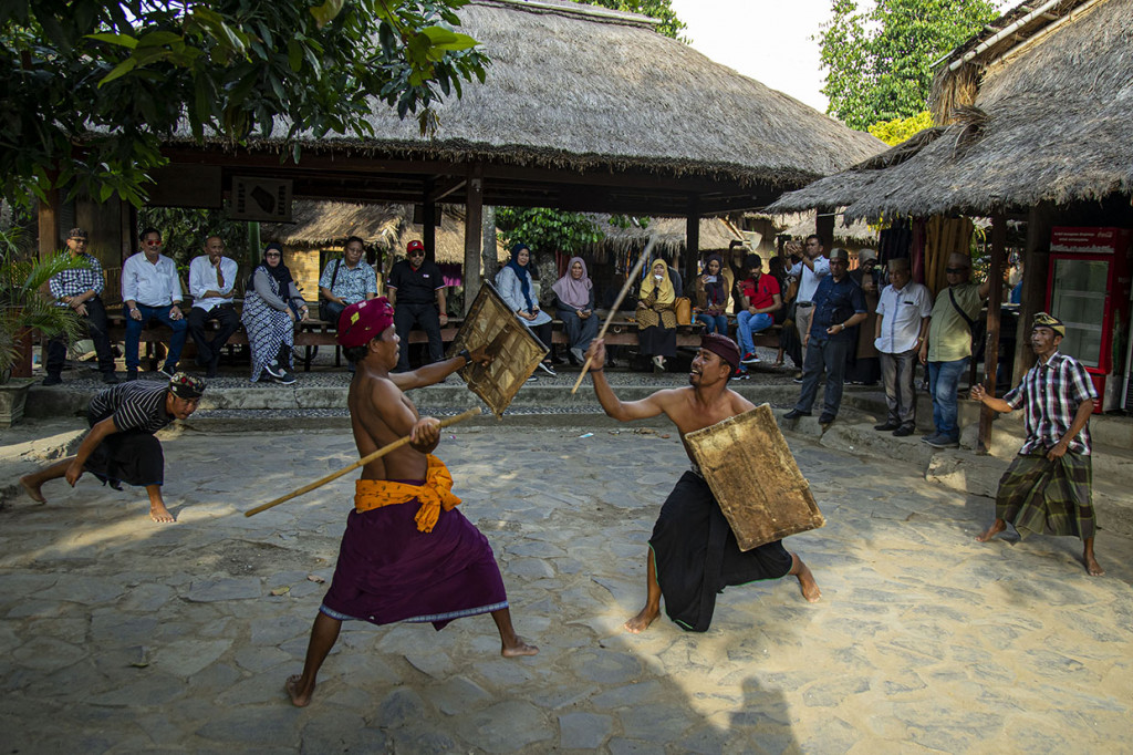 Warga bertarung dengan menggunakan rotan penjalin dan tameng yang terbuat dari kulit kerbau dalam tradisi Peresean di Kampung Adat Sasak Sade, Lombok Tengah, Nusa Tenggara Barat (NTB). 