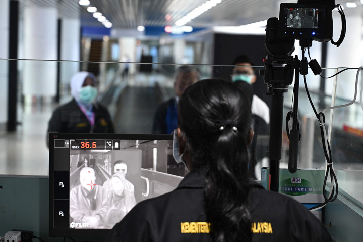 Petugas kesehatan memeriksa thermal scanner untuk mendeteksi suhu tubuh penumpang yang tiba di Bandara Internasional Kuala Lumpur.