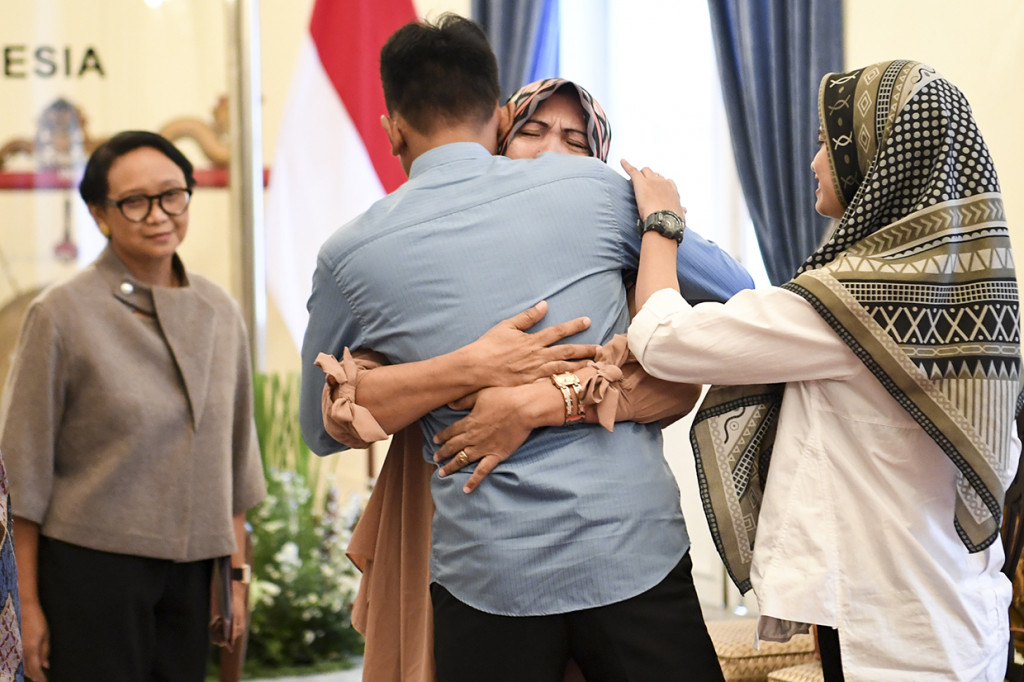 Korban penyanderaan kelompok gerilyawan Filipina Abu Sayyaf, Muhammad Farhan (kedua kiri) memeluk keluarganya disaksikan Menteri Luar Negeri Retno Marsudi (kiri) saat serah terima korban sandera ke keluarga di Kementerian Luar Negeri, Jakarta.