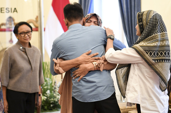 Korban penyanderaan kelompok gerilyawan Filipina Abu Sayyaf, Muhammad Farhan (kedua kiri) memeluk keluarganya disaksikan Menteri Luar Negeri Retno Marsudi (kiri) saat serah terima korban sandera ke keluarga di Kementerian Luar Negeri, Jakarta.