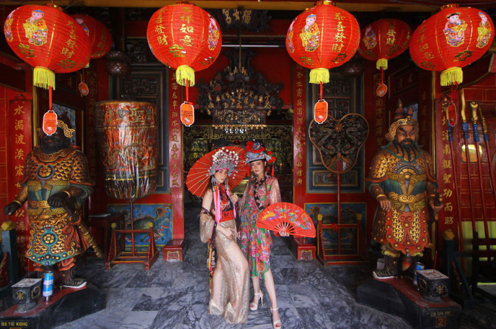 Desainer Stephanie Zhang (kiri) dan seorang model mengenakan busana tradisonal Tiongkok untuk perempuan (cheongsam) saat diperagakan di Klenteng Hok An Kiong, Surabaya, Jawa Timur, Kamis, 23 Januari 2020. 