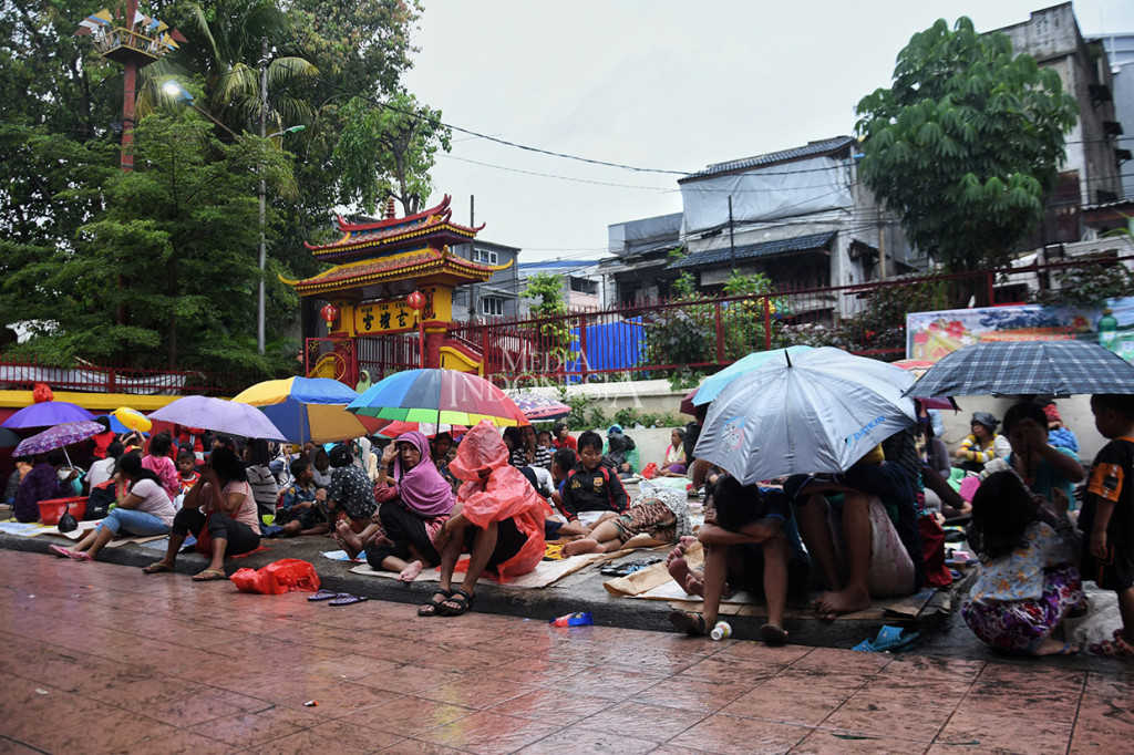 Meski hujan mengguyur, para pengemis musiman tetap bertahan di pelataran Wihara Dharma Bakti, Jakarta, Sabtu, 25 Januari 2020.