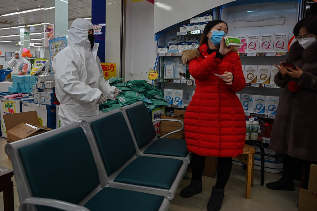 Petugas farmasi tengah melayani pembelian masker di Wuhan, Tiongkok, Sabtu, 25 Januari 2020. 