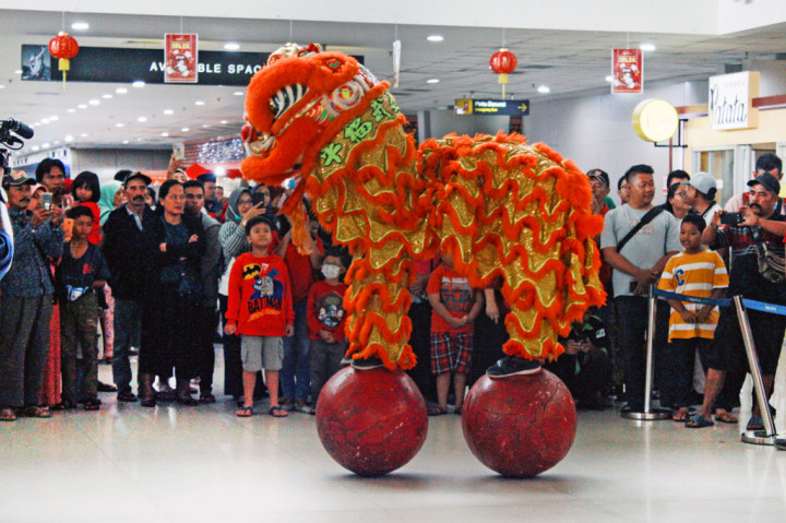 Penumpang dan pengguna jasa bandara menyaksikan pertunjukan barongsai di Terminal 2 Bandara Internasional Juanda, Surabaya, Jawa Timur. ANTARA FOTO/Umarul Faruq