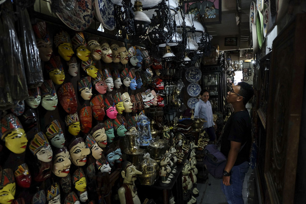 Pengunjung melihat-lihat koleksi barang antik yang dijual di Pasar Triwindu, Ngarsopuro, Solo, Jawa Tengah, Sabtu, 25 Januari 2020. 