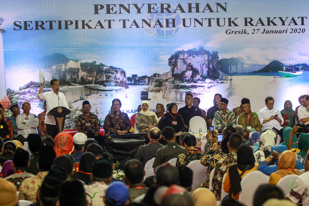 Presiden Joko Widodo menunjukkan sertifikat saat penyerahan Sertiikat Tanah untuk Rakyat di gedung Wahana Ekspresi Poesponegoro (WEP) Kabupaten Gresik, Jawa Timur.