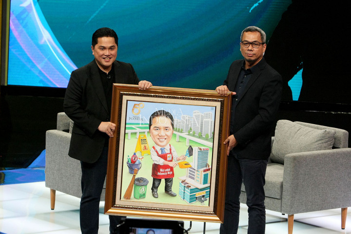Menteri Badan Usaha Milik Negara (BUMN) Erick Thohir (kiri) menerima kenang-kenangan berupa lukisan karikatur dirinya dari Direktur Pemberitaan Media Indonesia Usman Kansong seusai menyampaikan kuliah umum dalam rangka Ulang Tahun Ke-50 Media Indonesia.