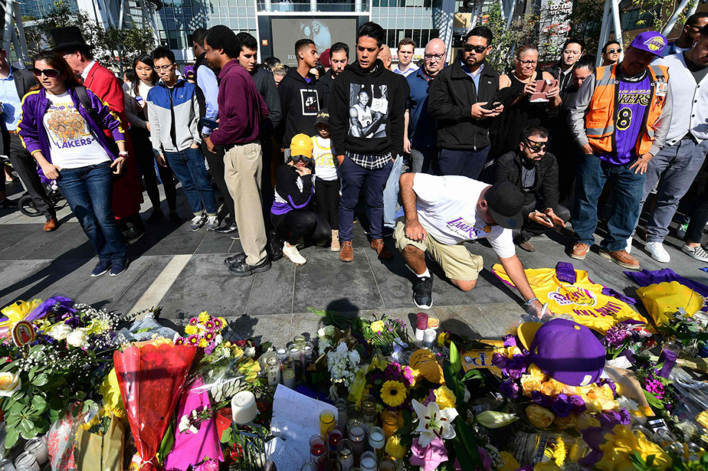 Para penggemar meletakkan karangan bunga, lilin, dan memorabilia untuk legenda NBA Kobe Bryant di luar Staples Center, markas LA Lakers, di Los Angeles, California pada Senin, 27 Januari 2020 waktu setempat.