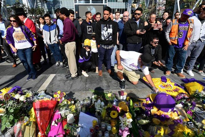 Para penggemar meletakkan karangan bunga, lilin, dan memorabilia untuk legenda NBA Kobe Bryant di luar Staples Center, markas LA Lakers, di Los Angeles, California pada Senin, 27 Januari 2020 waktu setempat.