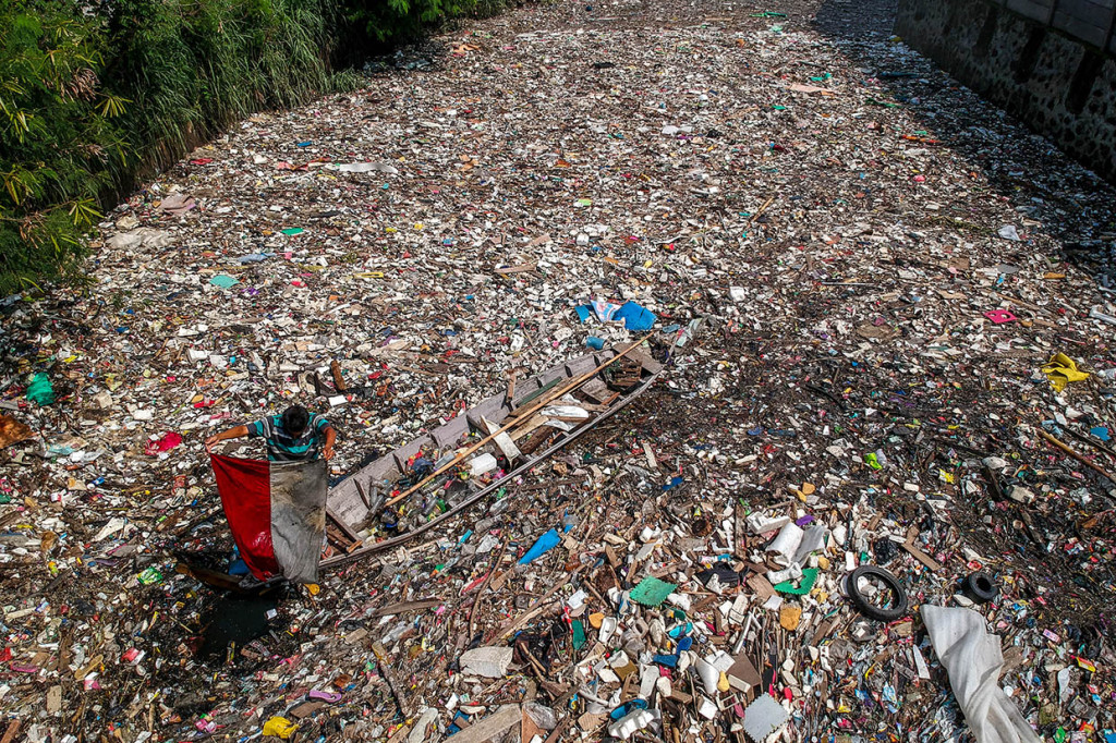 Seorang warga menemukan bendera Merah Putih di antara sampah plastik di Sungai Citepus yang bermuara ke Sungai Citarum di Bojong Citepus, Cangkuang Wetan, Dayeuhkolot, Kabupaten Bandung, Jawa Barat, Selasa, 28 Januari 2020.