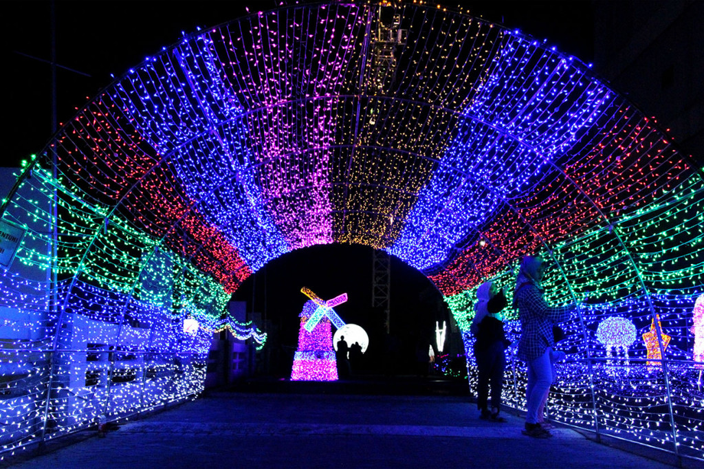 Pengunjung mengamati ornamen cahaya lorong pada Festival Lampu di Bekasi, Jawa Barat.
