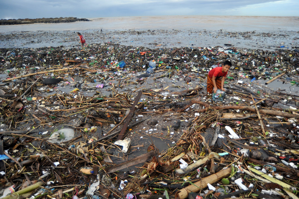 Anak-anak mengumpulkan kaleng dan botol minuman bekas, di antara sampah yang memenuhi kawasan Pantai Muaro Lasak, Padang, Sumatera Barat. Antara Foto/Iggoy el Fitra