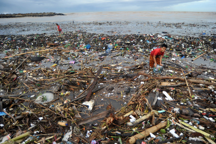 Anak-anak mengumpulkan kaleng dan botol minuman bekas, di antara sampah yang memenuhi kawasan Pantai Muaro Lasak, Padang, Sumatera Barat. Antara Foto/Iggoy el Fitra