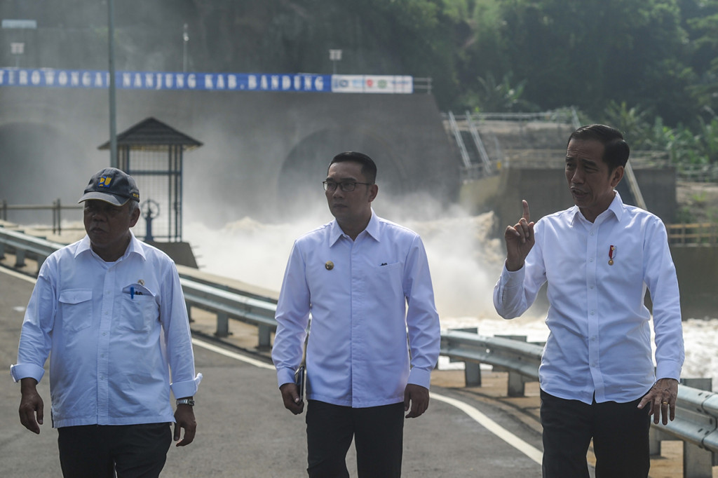 Presiden Joko Widodo (kanan) berbincang dengan Menteri PUPR Basuki Hadimuljono (kiri) dan Gubernur Jawa Barat Ridwan Kamil (tengah) saat peresmian Terowongan Air Nanjung di Margaasih, Kabupaten Bandung, Jawa Barat.
