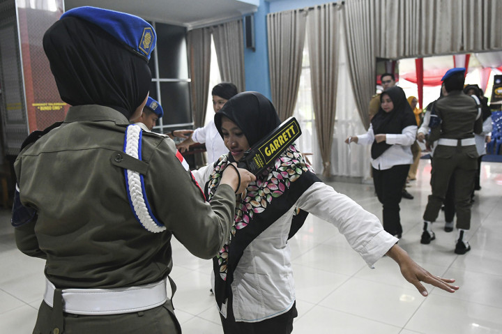 Anggota Satuan Polisi Pamong Praja memeriksa peserta sebelum memasuki ruangan Seleksi Kompetensi Dasar (SKD) berbasis Computer Assisted Test (CAT) untuk Calon Pegawai Negeri Sipil (CPNS) Provinsi Sumatera Selatan di aula SMK Negeri 2 Palembang, Sumatera Selatan. Antara Foto/Nova Wahyudi