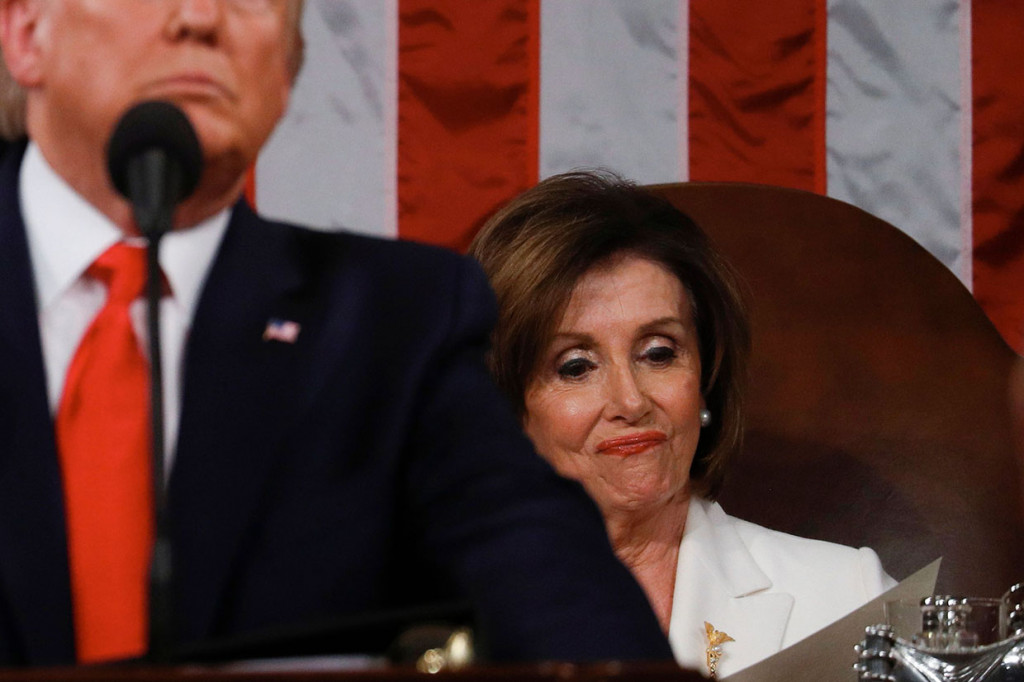 Saat Trump berpidato mengungkapkan berbagai pencapaiannya selama ini, Pelosi hanya tersenyum sinis.
