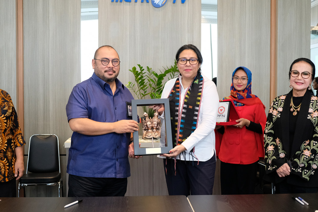 Direktur Utama Perum Perusahaan Film Negara (PFN) Judith Jubilina Navarro Dipodiputro dan CEO Media Group Mohammad Mirdal Akib bertukar cenderamata usai menandatangani MoU di Kantor Metro TV, Kedoya, Jakarta.
