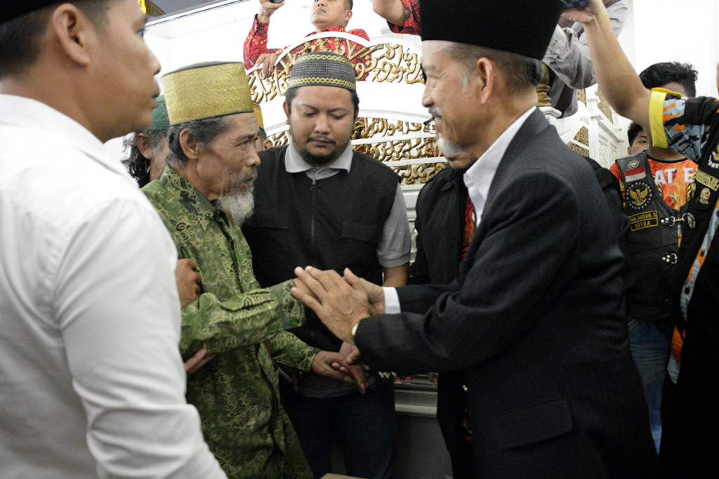 Pemimpin aliran kepercayaan tarekat Tajul Al Khalwatiyah Puang Lalang (kedua kiri) bersalaman dengan Ketua Majelis Ulama Indonesia (MUI) Gowa Abu Bakar Paka (kanan) saat melakukan kesepakatan perdamaian di Masjid Agung Syekh Yusuf, Kabupaten Gowa, Sulawesi Selatan.