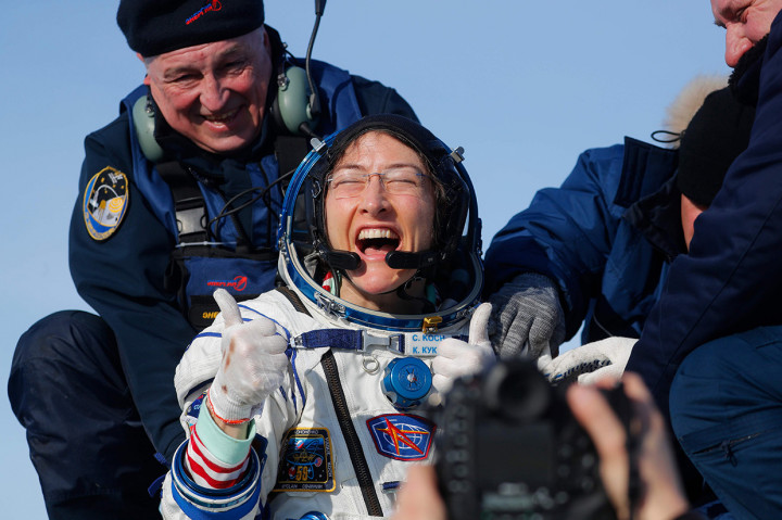 Koch tersenyum bahagia sesaat setelah keluar dari kapsul Soyuz MS-13 dan didudukkan di kursi untuk pemeriksaan.