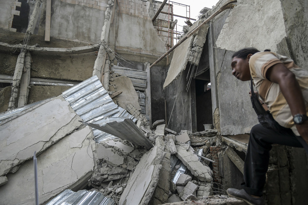 Warga melihat bangunan yang ambruk di Jalan Pisangan Baru, Matraman, Jakarta.