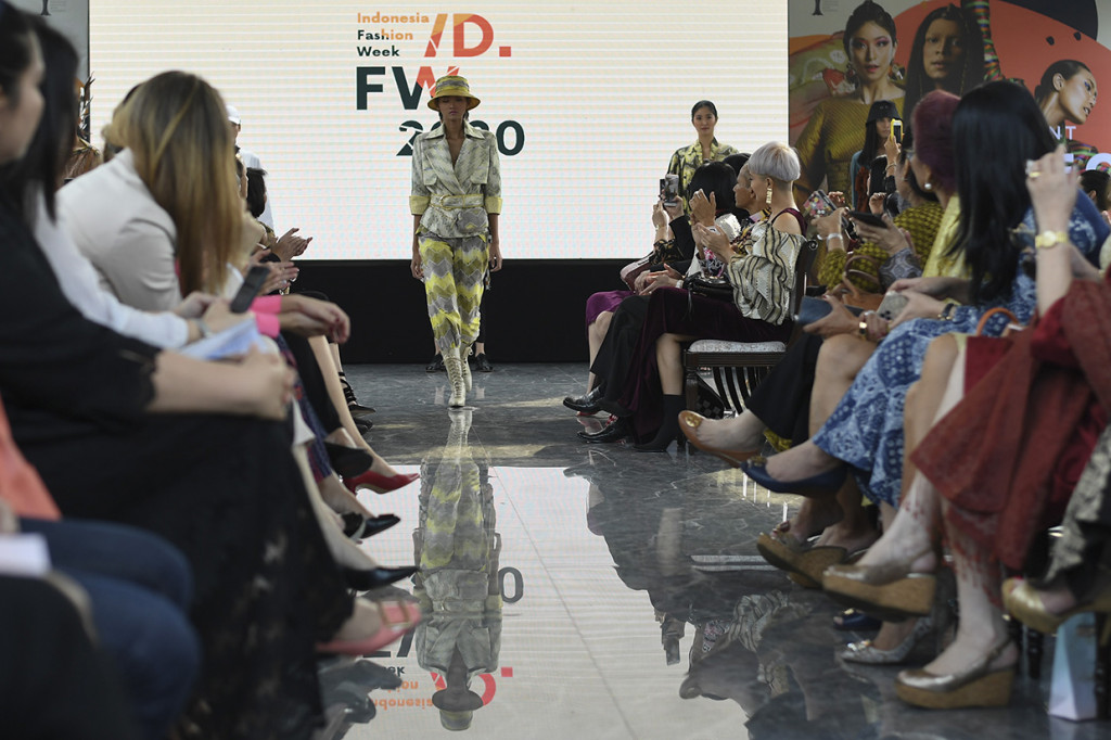 Model menampilkan rancangan busana saat 