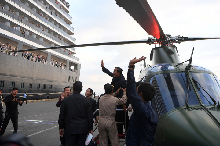 Perdana Menteri Kamboja Hun Sen melambaikan tangan kepada para penumpang kapal pesiar Westerdam, setelah tiba di Pelabuhan  Sihanoukville dengan helikopter, Jumat, 14 Februari 2020.