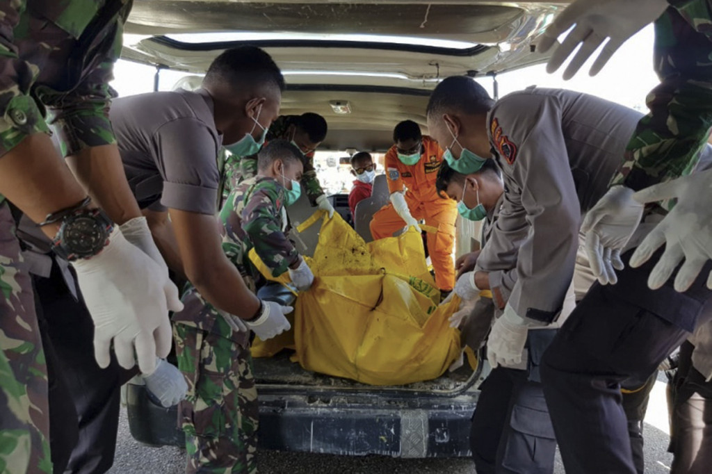 Prajurit TNI dan Polri membawa kantong jenazah penumpang Heli M-17 yang hilang di pegunungan Mandala, Distrik Oksop, Kabupaten Pegunungan Bintang pada 28 Juni 2019 setibanya di bandara Oksibil, Kabupaten Pegunungan Bintang, Papua.