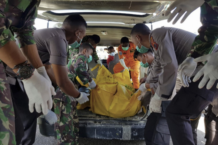 Prajurit TNI dan Polri membawa kantong jenazah penumpang Heli M-17 yang hilang di pegunungan Mandala, Distrik Oksop, Kabupaten Pegunungan Bintang pada 28 Juni 2019 setibanya di bandara Oksibil, Kabupaten Pegunungan Bintang, Papua.