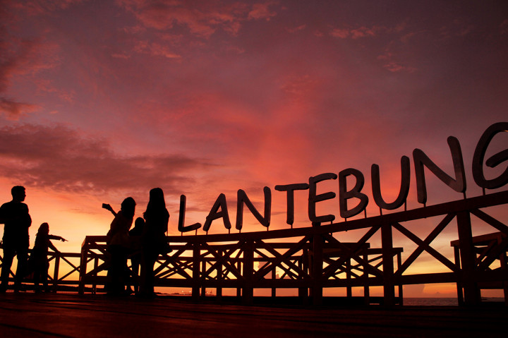 Pengunjung berswafoto saat matahari tenggelam di kawasan hutan mangrove Lantebung di Makassar, Sulawesi Selatan.