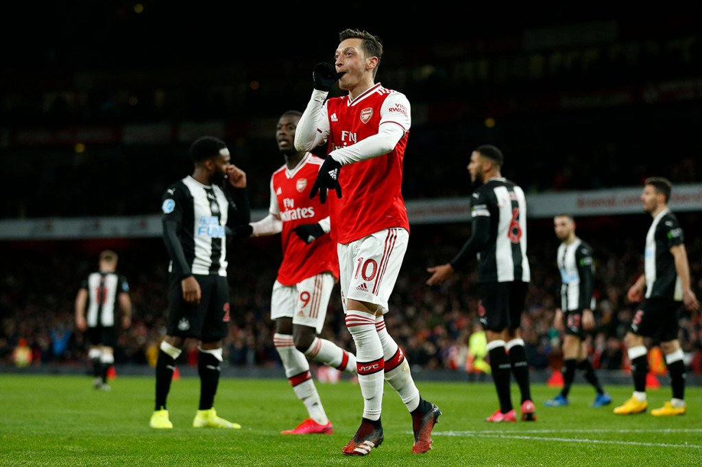Mesut Ozil melakukan selebrasi usai mencetak gol ke gawang Newcastle United.


