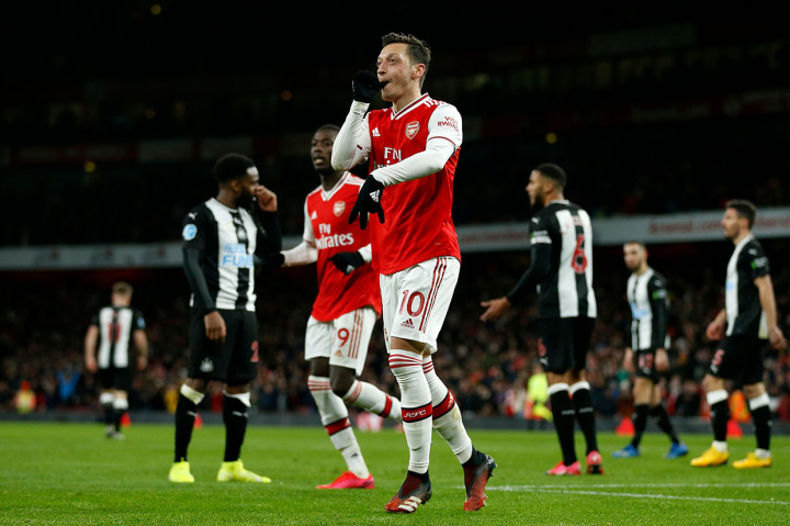 Mesut Ozil melakukan selebrasi usai mencetak gol ke gawang Newcastle United.

