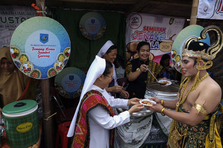 Peserta membagikan jenang kepada warga berkostum wayang pada acara Semarak Jenang Sala 2020 di Ndalem Djojokusuman, Solo, Jawa Tengah.