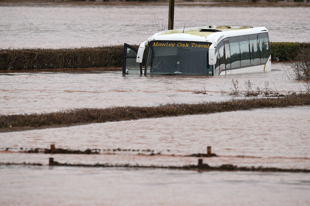 Sebuah bus terendam di Lindridge, Inggris, terendam banjir. AFP Photo/Oli Scarff