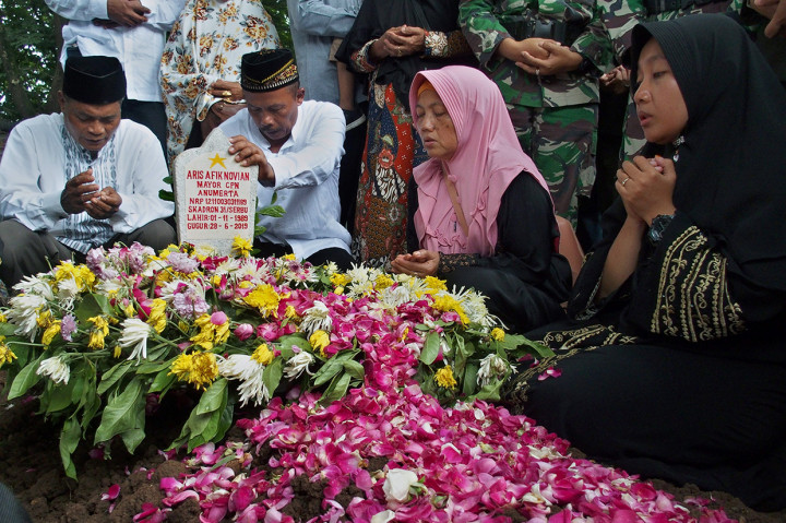 Kerabat berdoa di atas pusara salah satu korban yang gugur dalam kecelakaan Helikopter Mi-17 di Papua, Mayor CPN Anumerta Aris Afik Novian, saat pemakaman di Taman Makam Pahlawan (TMP) Giri Tunggal Semarang.